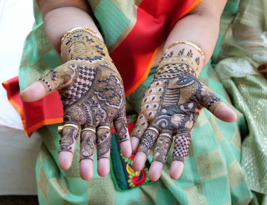 Indian woman's hands with henna designs on palms.