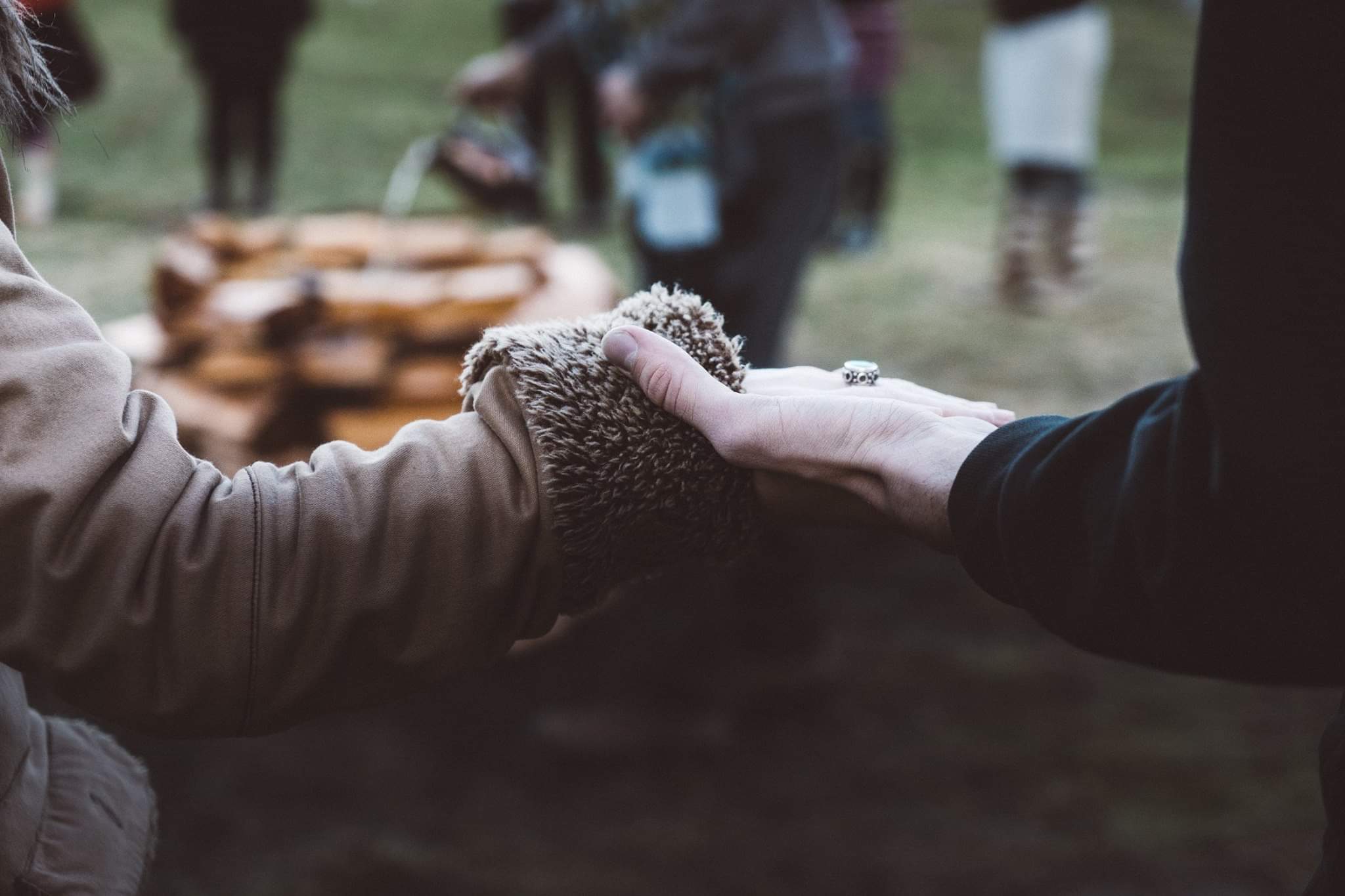 Hands holding in a circle around a fire